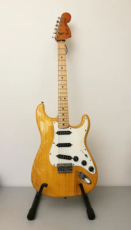 Sähkökitara Fender Stratocaster 1977, käytön jälkiä, lavan pää korjattu, made in USA, sarjanumero S 779924, natural, saarnirunko, vaahterakaula, pinta uudelleen lakattu, kaulan takaa hiottu lakkaus pois, mikrofoninvalitsimesta puuttuu toinen kiinnitysruuvi, pehmeä laukku. Ota yhteys panttilainaamoon kuljetusmaksusta sopimiseksi.