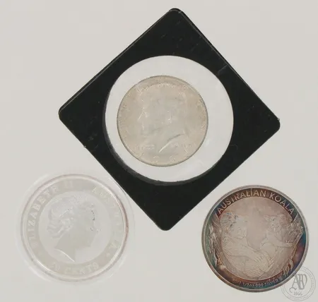 Kolme hopearahaa, yksi 1964 Kennedy Half Dollar, 900, kaksi 2011 Australian Koala 50 Cents, 999, paino yhteensä 43,6g