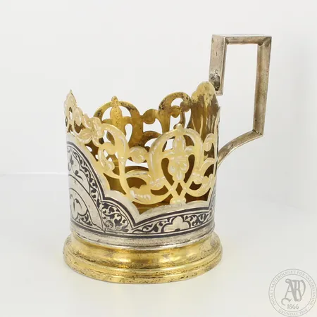 Metallikahva teelasiin, pohjassa kolhu, metallia