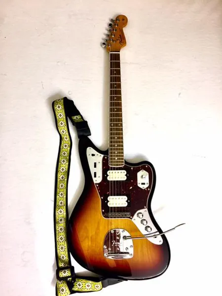 Sähkökitara Fender Kurt Cobain Jaguar, 3-tone sunburst, leppärunko, vaahterakaula, reunanauhoitettu ruusupuuotelauta, DiMarzio DP103 and DP100 humbucker mikrofonit, Gotoh virittimet, Adjusto-matic talla, pehmeä laukku Ota yhteys panttilainaamoon kuljetusmaksusta sopimiseksi.
