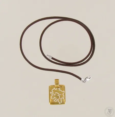 Leijona-riipus kultaa ja nahkanauha hopeaheloilla 925, riipuksen korkeus 37mm, nauhan pituus 41,5cm, 750, riipuksen paino 3,5g
