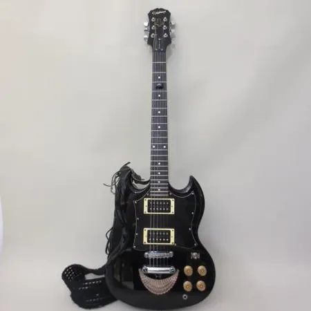 Sähkökitara Epiphone Gibson SG, sarjanumero SJ04010566,  vuodelta 2004, Made by SaeJun, China, kova laukku, käytön jälkiä, runkoon liimattu koristeita. Ota yhteys panttilainaamoon kuljetusmaksusta sopimiseksi.
