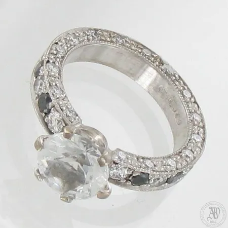 Valkosafiirisormus timanteilla 32xn.0.02ct 12xn.0.05ct ja safiiri 2.0ct, koko 15½, 585br valkokultaa, paino 5,7g