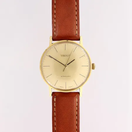 Kultarannekello, Tissot Stylist, manuaali, taulun pleksilasissa naarmuja ja kulumaa, taulun Ø33mm, nahkaranneke, 585br, 