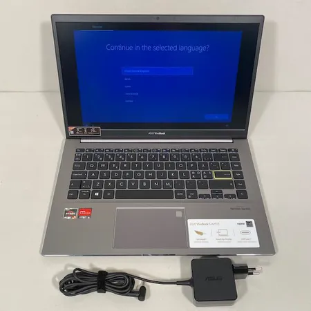 Tietokone Asus Vivobook S14 ja virtajohto. 