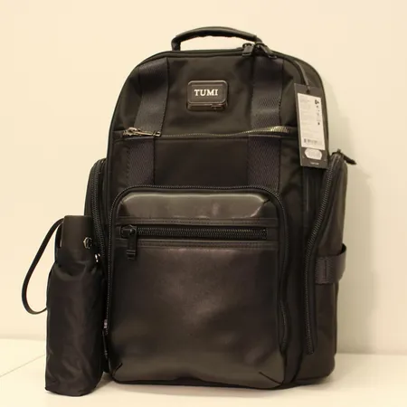 Reppu Tumi Alpha Bravo Sheppard Deluxe Brief Pack, nahka/polyesteri, mukana Tumi-sateenvarjo, kuin uusi.