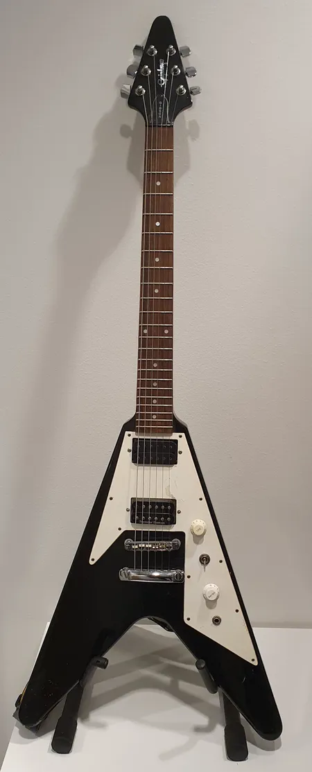 Sähkökitara Epiphone Flying V, käytön jälkiä, halkeamia maalipinnoissa, mikrofoni-valitsimen nuppi puuttuu, tallamikrofoni Seymou Duncan, S:N S97085695, kulunut kova laukku 
