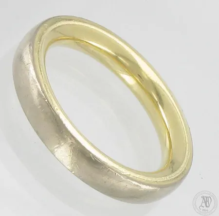 Sileä sormus, koko 21½, leveys 4,5mm, sisäpuoli pyöristetty, pinnassa käytön jälkiä, 585 kelta- ja valkokulta,  Paino: 14,5 g
