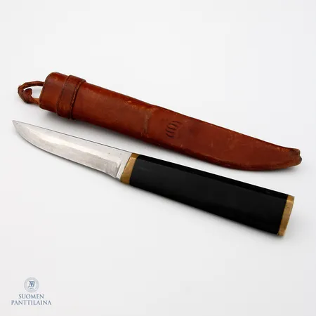 Puukko, Design Tapio Wirkkala, ruostumatonta terästä, nailonia ja messinkiä, terässä käytön jälkiä