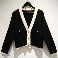 Chanel- neule, Cardigan Cashmere Cotton & Mixed Fibers Black, White & Gold, koko 40, Chanel Cruise- collection 2023/24, ref.P76581 K11024 NU481, irroitettava paljettihuppu, 78% kashmir ja 22% puuvilla, Made in Italy, kopio ostokuitista Mall of the Emirates 28.12.2023, alkuperäinen dustbag, pientä nukkaantumista.