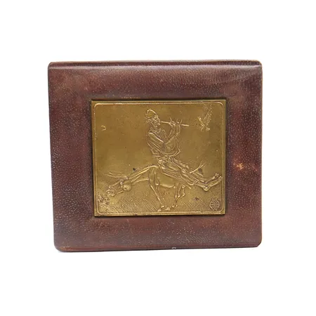 Pronssitaulu nahkaisella alustalla, Pilliä soittava mies hevosen päällä, korkeus 13cm, leveys 15cm, tekijä tuntematon. 