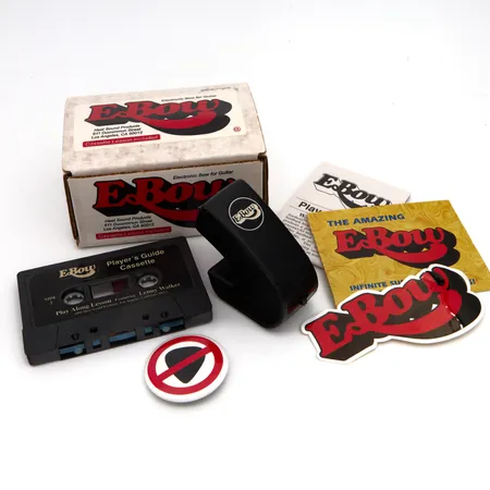 Sähköjousi E-Bow, mukana manuaali, rintamerkki, esite, tarra, kasetti, pussi ja laatikko