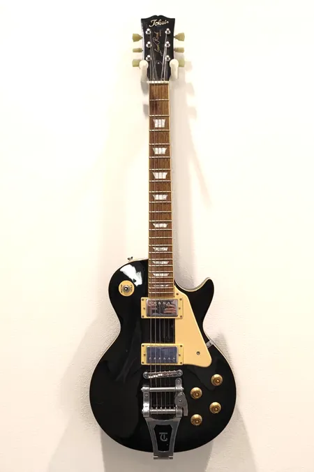 Sähkökitara Tokain Love Rock, SN: 100060, mikrofonivalitsimen nuppi poissa, kaksi humbucker-mikrofonia, 2x volume 2xtone, bigsby-tyylinen talla viallinen (kampi irti), käytön jälkiä, hihna, kova kantolaukku