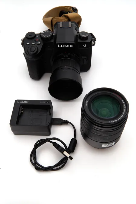 Järjestelmäkamera Panasonic Lumix Dc-G90, kaksi objektiivia Panasonic G 1:1.7 / 42.5 ASPH. O.I.S. H-HS043 ja G VARIO 1:3.5-5.6 / 14-140 ASPH. POWER O.I.S. H-FS14140, akku, laturi ja USB-johto