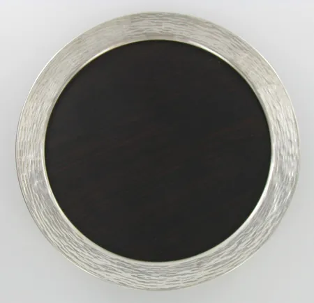 Tarjotin, design Tapio Wirkkala, 925 ja jakaranda, vuodelta 1973, Ø 245mm, paino 339,5g. Hintaan lisätään Tekijänoikeuslain mukainen jälleenmyyntikorvaus 5%, johon lisäämme voimassa olevan alv:n mikäli viimeinen huutohinta ylittää 255,00 euroa.