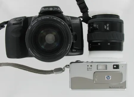 Filmikamera Minolta Dynax 500si ja kaksi linssiä: Minolta AF 70-210 ja AF 35-70, Viallinen digikamera HP photosmart 435, 3.1MP 5xZoom, kameralaukku