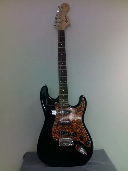 Sähkökitara Squier Strat by Fender Seymour Duncan mikeillä, takakansi ja yksi virityskoneiston jousi puuttuu, laukku