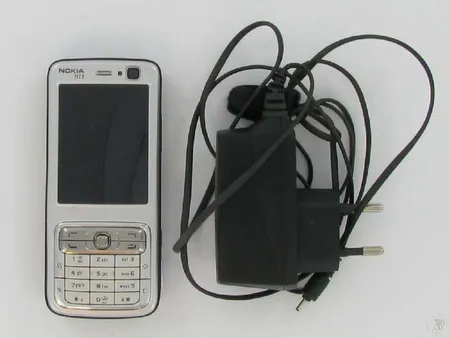 Gsm-matkapuhelin Nokia n73, laturi ja kantohihna laatikossa