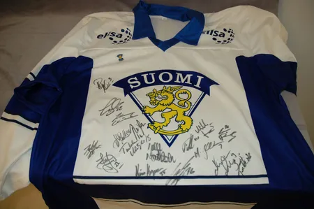 Suomen maajoukkue pelipaita pinssillä ja nimikirjoituksilla